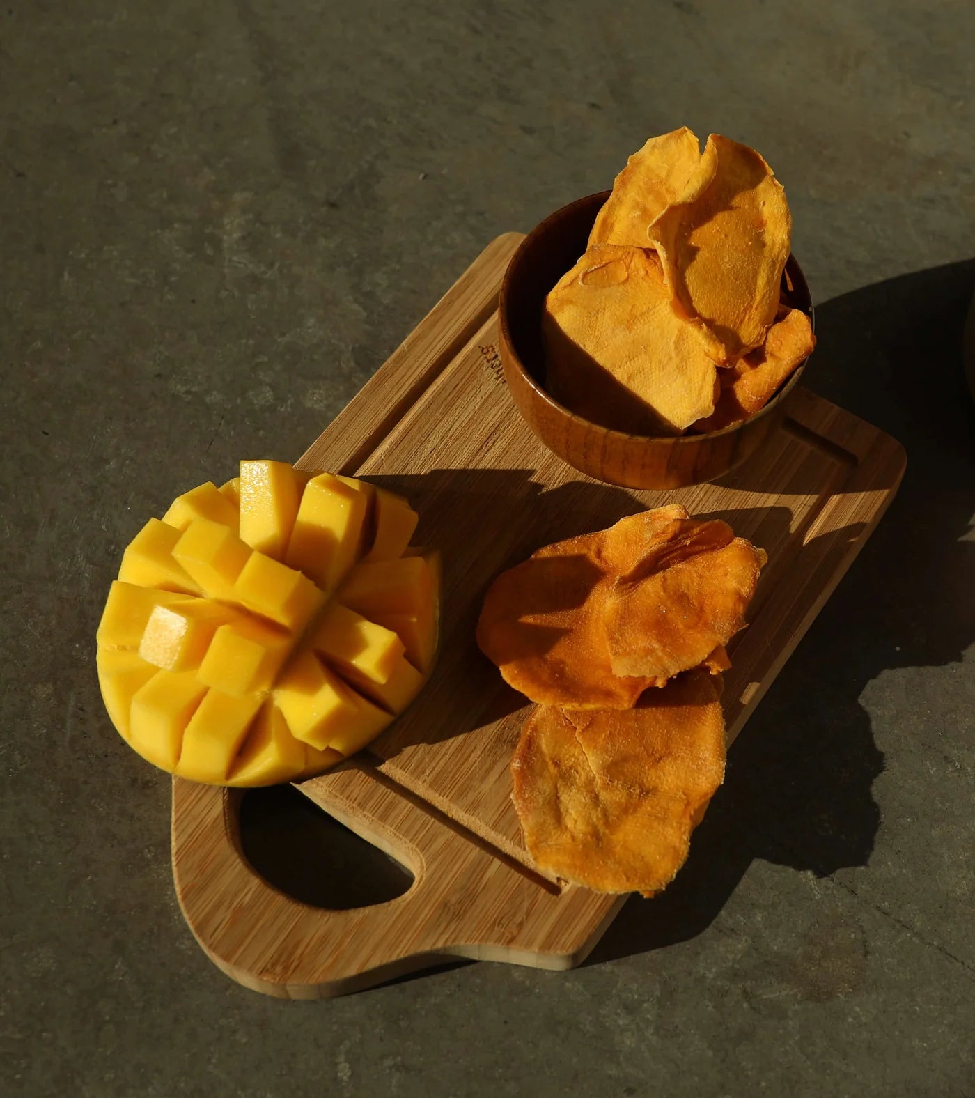 Photo shoot for Off the Tree Snacks showing dried mango cheeks next to ripe mango.